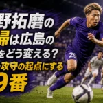 紫のユニフォームを着たサッカー選手がスタジアムで前方へ走り出す様子。