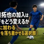 青いユニフォームのMFが中盤でボールを落ち着いて扱う場面。
