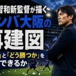 スタジアムのピッチ脇から選手の練習を見守るサッカー監督。