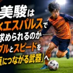 オレンジ色のウェアを着た若手MFがピッチでドリブルするイメージ。