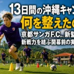 沖縄の緑のピッチでトレーニングに取り組む紫色のウェアのサッカー選手たち。