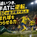 雨上がりのスタジアムで栃木SCが終盤のこぼれ球から決勝点を狙う場面。