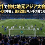 ナイターの雨のスタジアムで、青いユニフォームの若い選手たちが密集した守備ブロックに挑む場面