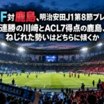 ナイターの照明に照らされたサッカースタジアムと、キックオフを待つピッチの様子