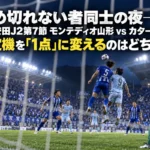 ナイターの競技場で、ペナルティエリアに入ったクロスに競り合う両チームの選手たち。