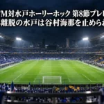 ナイターの照明に照らされた大型サッカースタジアムのピッチと観客席。