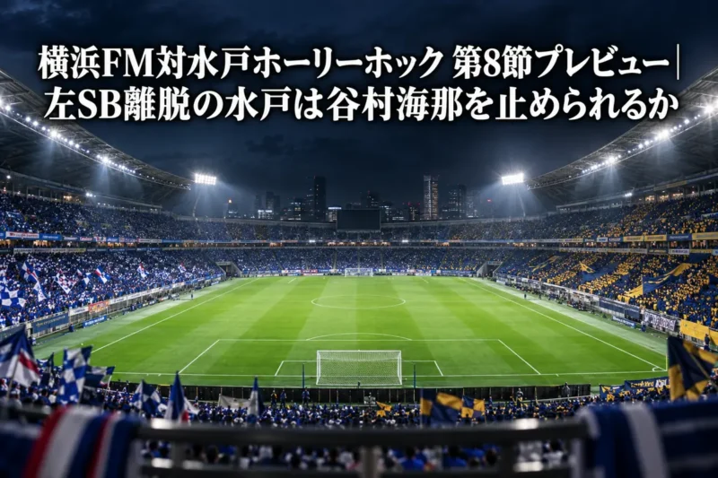 ナイターの照明に照らされた大型サッカースタジアムのピッチと観客席。