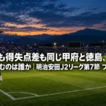 ナイトゲーム前、照明に照らされたスタジアムのピッチと山並みの夕暮れ空。
