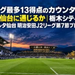 夕方のキックオフ前、照明が灯ったサッカースタジアムとスタンドに集まるサポーター。
