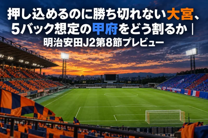 夕暮れの照明が灯りはじめたサッカースタジアムのピッチと観客席を見渡した写真