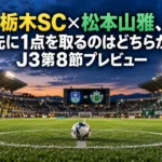 栃木SC×松本山雅、先に1点を取るのはどちらか|J3第8節プレビュー 夕暮れの照明が灯るスタジアムのピッチとセンターサークルに置かれたボール。
