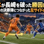 夜のスタジアムで左サイドから中央へ攻撃をつなぐオレンジのユニフォームの選手たちのイメージ。