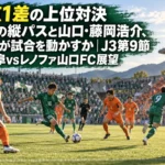 秋の日差しの中、スタジアムで縦パスを狙う選手と裏へ走るストライカーの試合風景