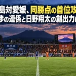 照明がともる夕方のサッカースタジアムでキックオフを待つ選手たちのイメージ。