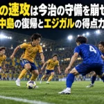 仙台の速攻は今治の守備を崩せるか 石井・中島の復帰とエジガルの得点力に注目 照明に照らされたサッカー場で、金色のユニフォームの攻撃側と青色の守備側が向き合うイメージ。