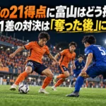 大宮の21得点に富山はどう挑む?勝点1差の対決は「奪った後」に注目 照明に照らされたピッチでオレンジと青の選手がボールを奪い合うイメージ。