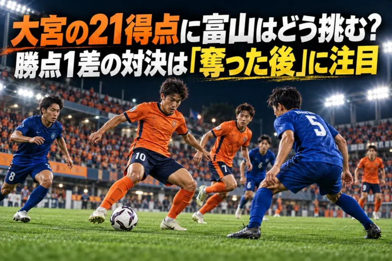 照明に照らされたピッチでオレンジと青の選手がボールを奪い合うイメージ。
