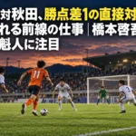 夜のサッカースタジアムで前線の選手と守備陣が対峙するイメージ。