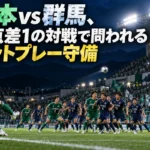 松本vs群馬、勝点差1の対戦で問われるセットプレー守備 夜のスタジアムでコーナーキックに備える緑と紺のユニフォームの選手たち。