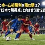 讃岐のホーム初勝利を阻む壁は?金沢「13本で無得点」と向き合う第12節 照明に照らされたサッカー場で青と赤のユニフォームの選手がボールを競うイメージ。