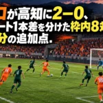 山口が高知に2-0、シュート1本差を分けた枠内8対5と55分の追加点 オレンジと緑のユニフォームの選手が対峙するサッカースタジアムのイメージ。