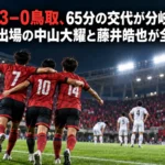 熊本3-0鳥取、65分の交代が分岐点に 途中出場の中山大耀と藤井皓也が全得点 照明に照らされたサッカー場で得点を喜ぶ赤いユニフォームの選手たちのイメージ。